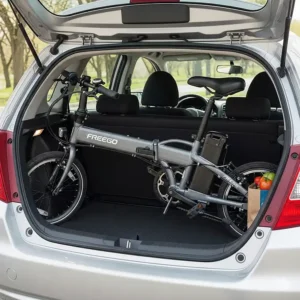 A folded Freego electric bike fitting perfectly into the trunk of a small car, highlighting its portability.