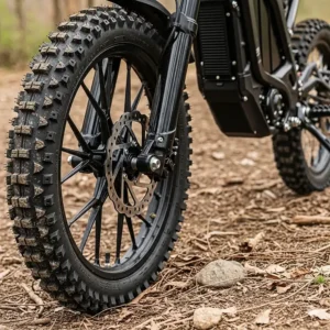 Knobby off-road tires on a 48 volt electric dirt bike, designed to provide maximum grip and stability on various surfaces.