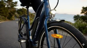A detailed photorealistic close-up capturing the front wheel and integrated high-intensity LED headlight of a modern electric bike for safe travel at dusk.