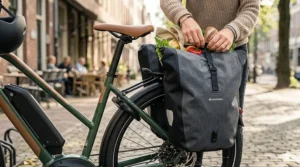 Close-up of a sturdy rear rack on an electric bike carrying two large waterproof pannier bags.