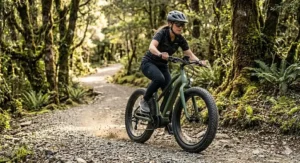An all-terrain fat tire electric bike around $1500 riding over a gravel trail in nature.