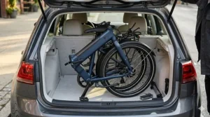 A compact folding electric bike being stored in a car trunk to show portability for under $700.
