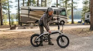 A person unfolding a portable electric bike at a scenic American campground for RV travel