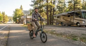 A person riding a folding ebike to a nearby grocery store while camping in an RV