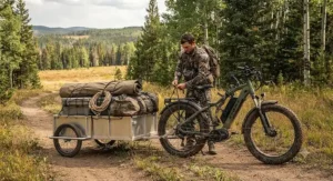 An affordable electric hunting bicycle equipped with a heavy-duty cargo trailer for hauling gear through backcountry public land.