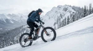 A cyclist powering up a steep, snowy mountain slope on an electric fat bike.