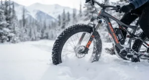 Close-up of a fat tire electric mountain bike plowing through deep powder snow.