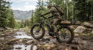 A fat tire electric hunting bike navigating muddy and rocky terrain on a backcountry elk hunting excursion.