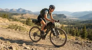 A rider efficiently climbing a steep incline on a gravel ebike for bikepacking trips.