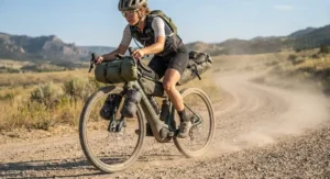 A close-up of a gravel ebike for bikepacking trips riding along a dusty rural gravel road.