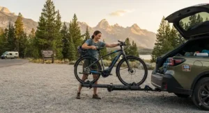 A person unloading a lightweight touring electric bike with a 100-mile range from a car rack at a national park.