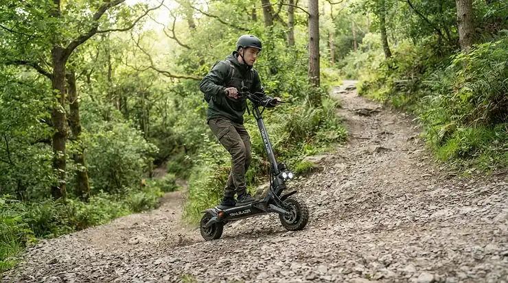 An adventurer tackling dual motor electric scooter hill climbing on a loose gravel trail.