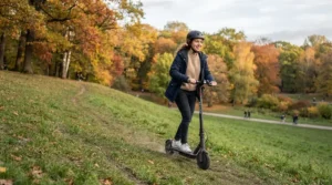 Trying out dual motor electric scooter hill climbing across a grassy park hill during autumn.