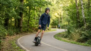 A tall teenager riding an electric scooter for teenagers that easily supports a higher weight capacity on a park path.