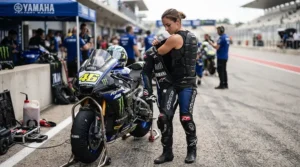 A racer suiting up in the paddock with a back protector for superbike track days ready.