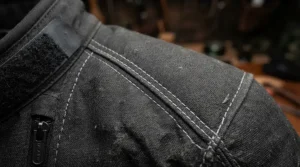 A detailed look at the heavy-duty fabric weave of a motorcycle riding jacket with armor for naked bike riders during a gear check.